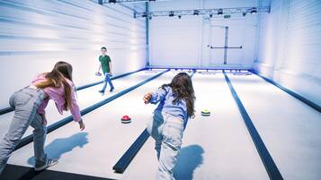 Uma pista de curling coberta com jogadores e pedras de curling.