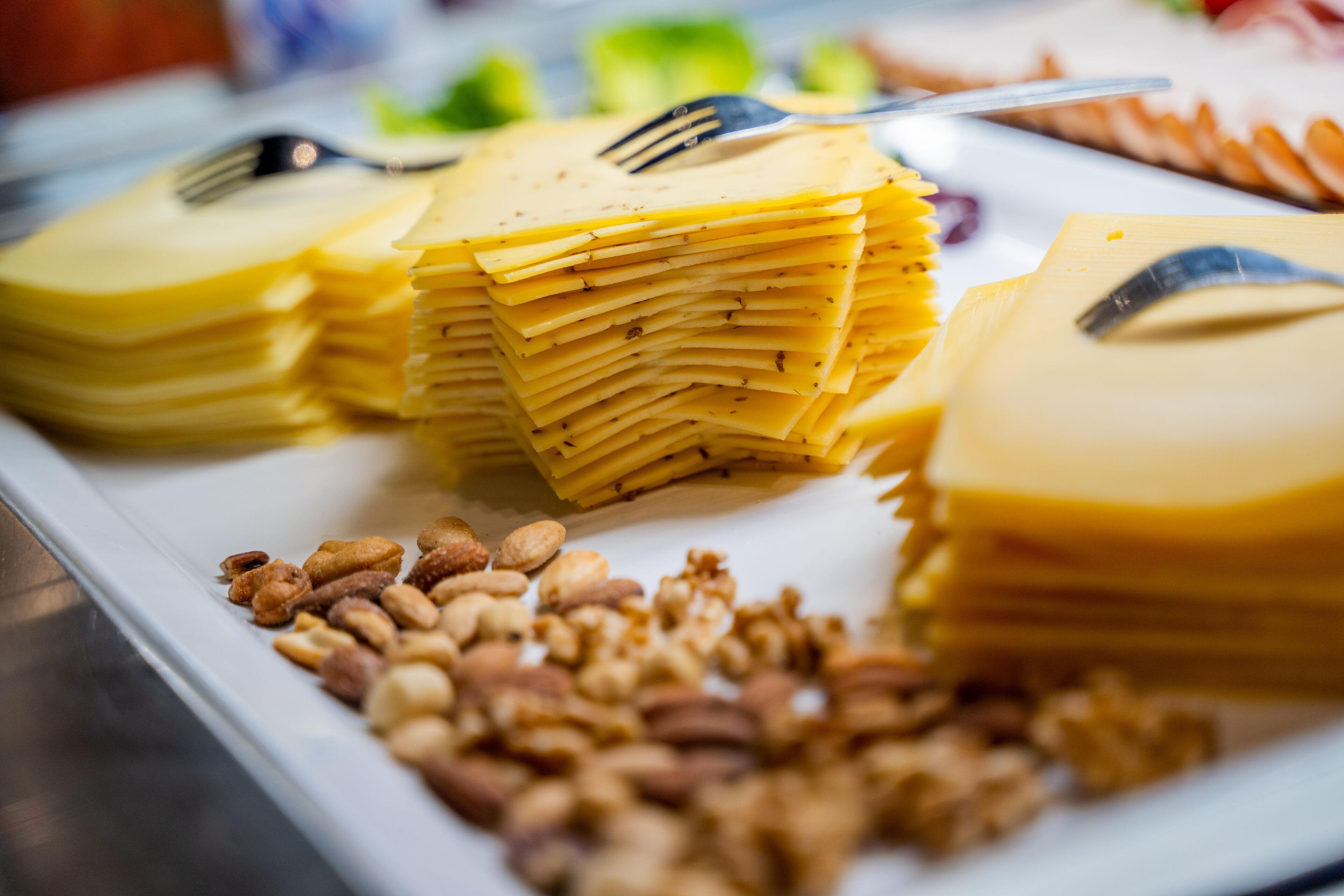 Una mesa de buffet con quesos y frutos secos apilados.