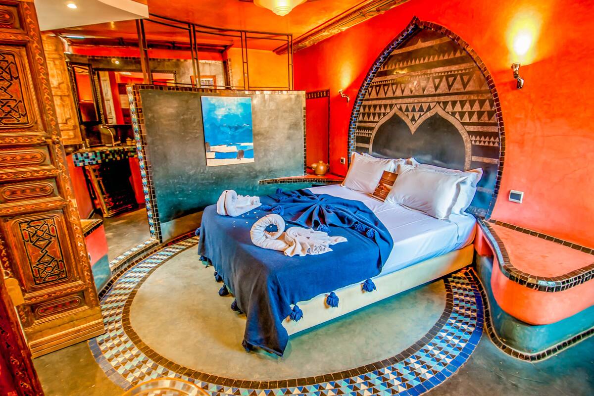 Een kamer met een bed, een decoratieve wand en een patroon vloer.