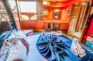 A room with a bed, a chair, a small table, and a window. - Riad Chorfa (Marrakech)