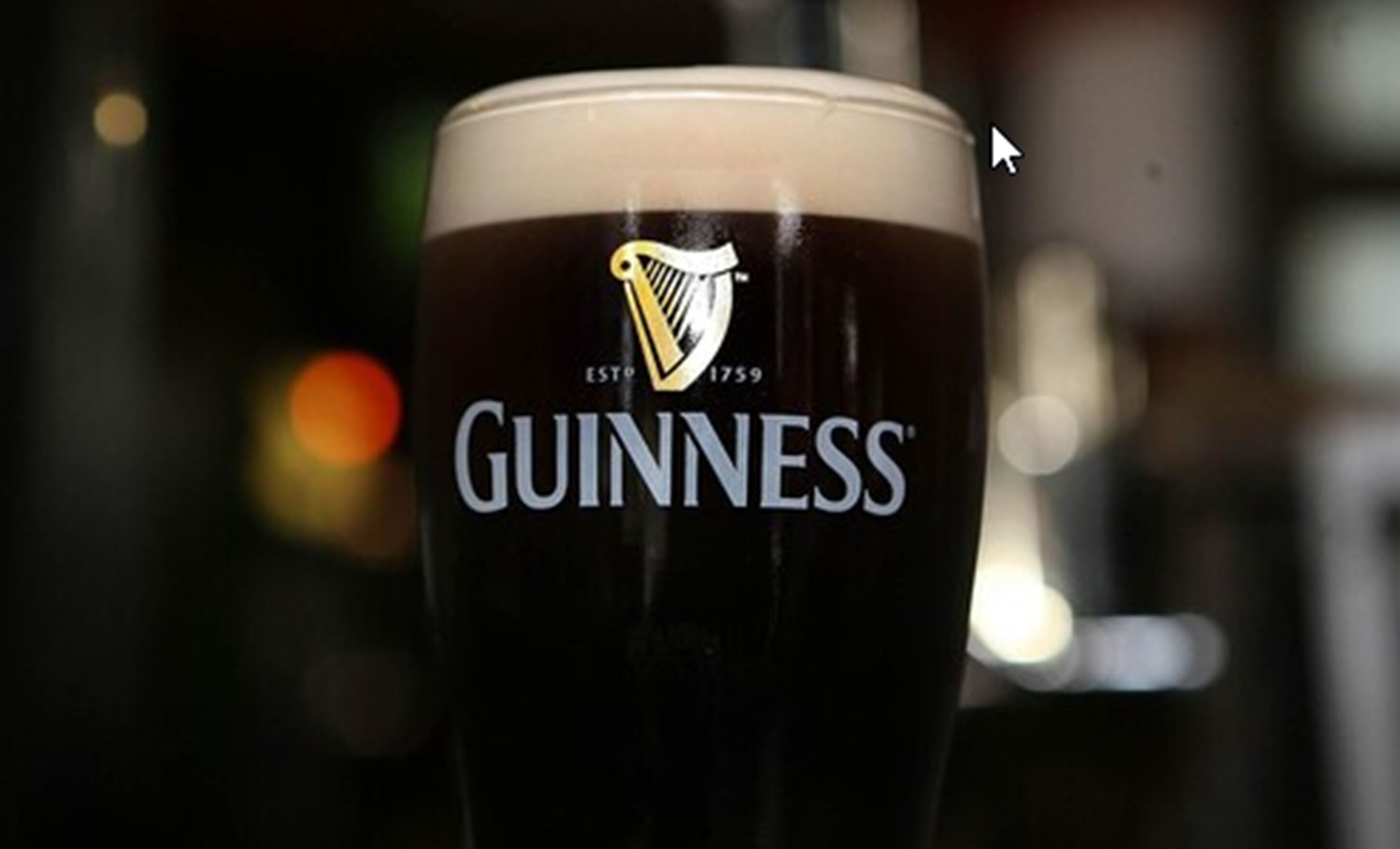 A glass of Guinness beer with the logo and establishment year visible.