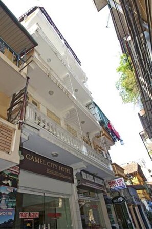 A multi-story building with a sign for "Camel City Hotel" and "Travel Agency" on the ground floor.