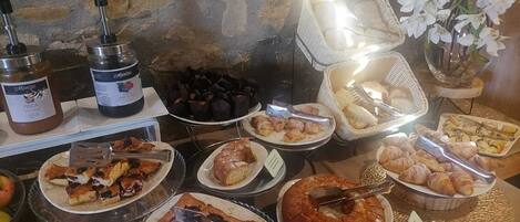 A buffet with various food items including pastries, cakes, and desserts.