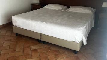 Un dormitorio con una cama, dos mesitas de noche y un cuadro en la pared.