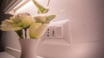A white wall with a power outlet and a USB port.