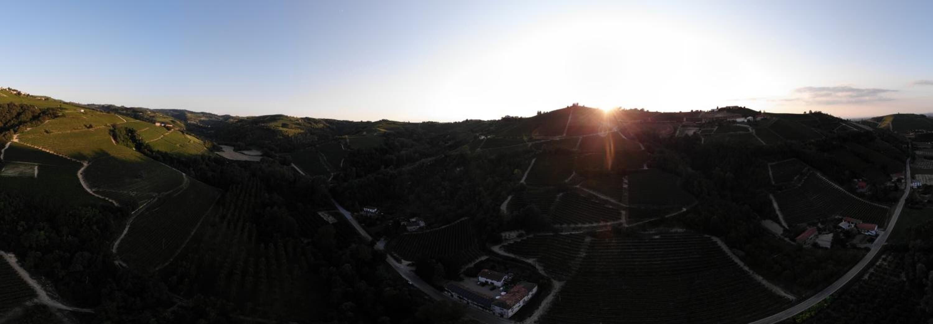 A panoramic view of a valley with terraced fields and a small settlement.