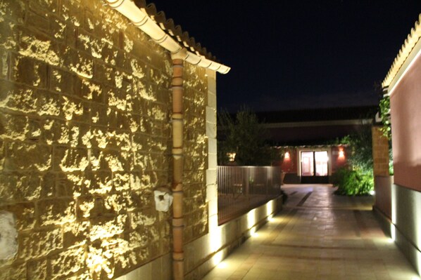Un edificio de piedra con un camino empedrado que lleva a una entrada iluminada.
