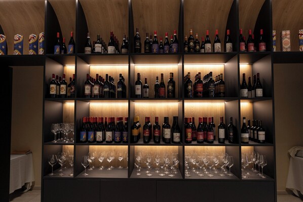 A wine cellar with multiple shelves of wine bottles and glasses.