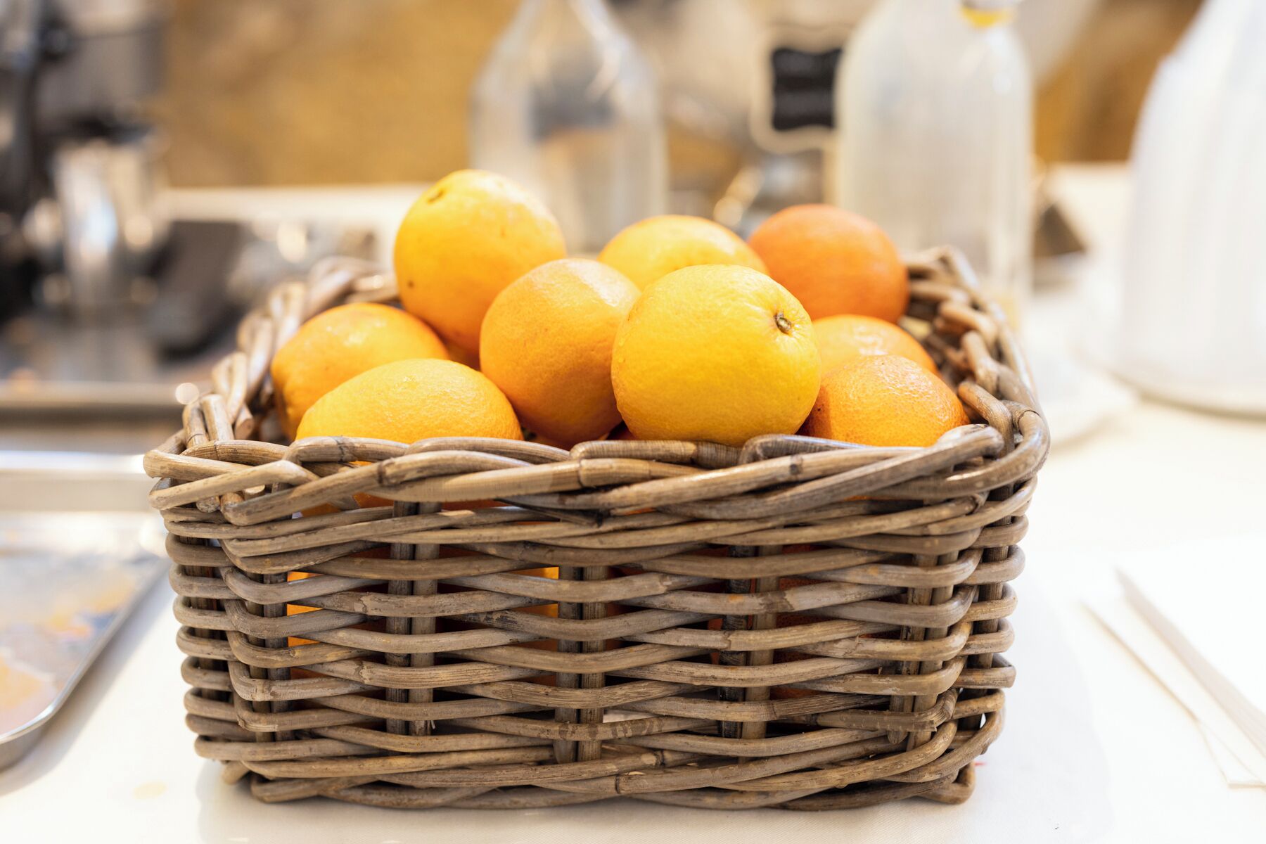 Ein Korbkistchen voller Orangen auf einem Tisch.