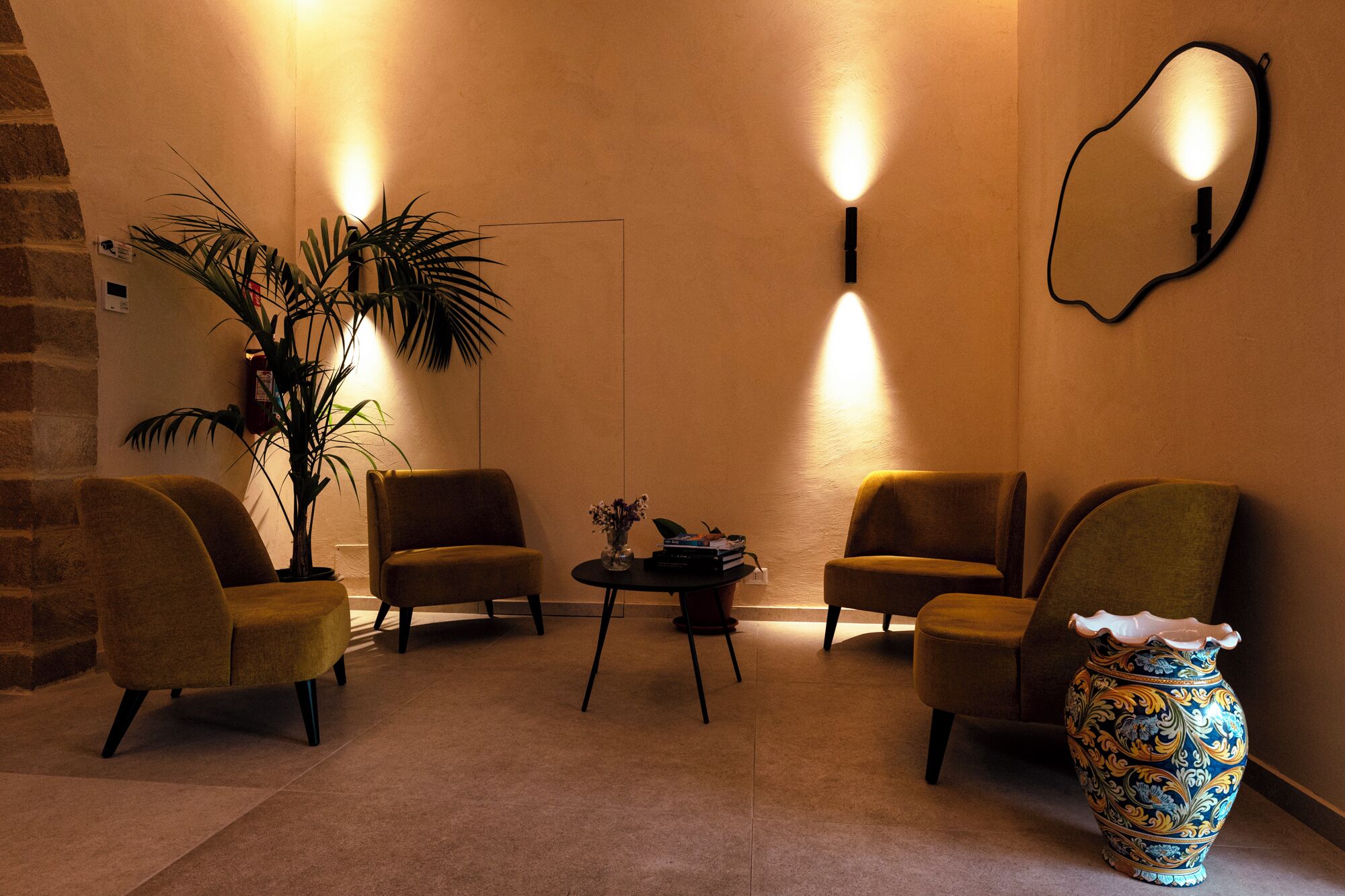 A cozy lounge area with two armchairs, a small table, and a decorative vase.
