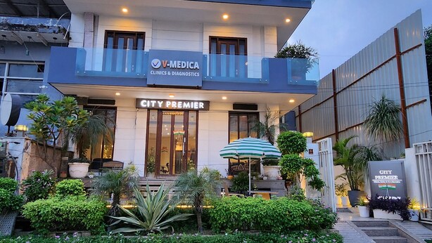 A multi-story building with a sign for V-MEDICA Clinics & Diagnostics and City Premier hotel. - Hotel City Premier (Gurugram)