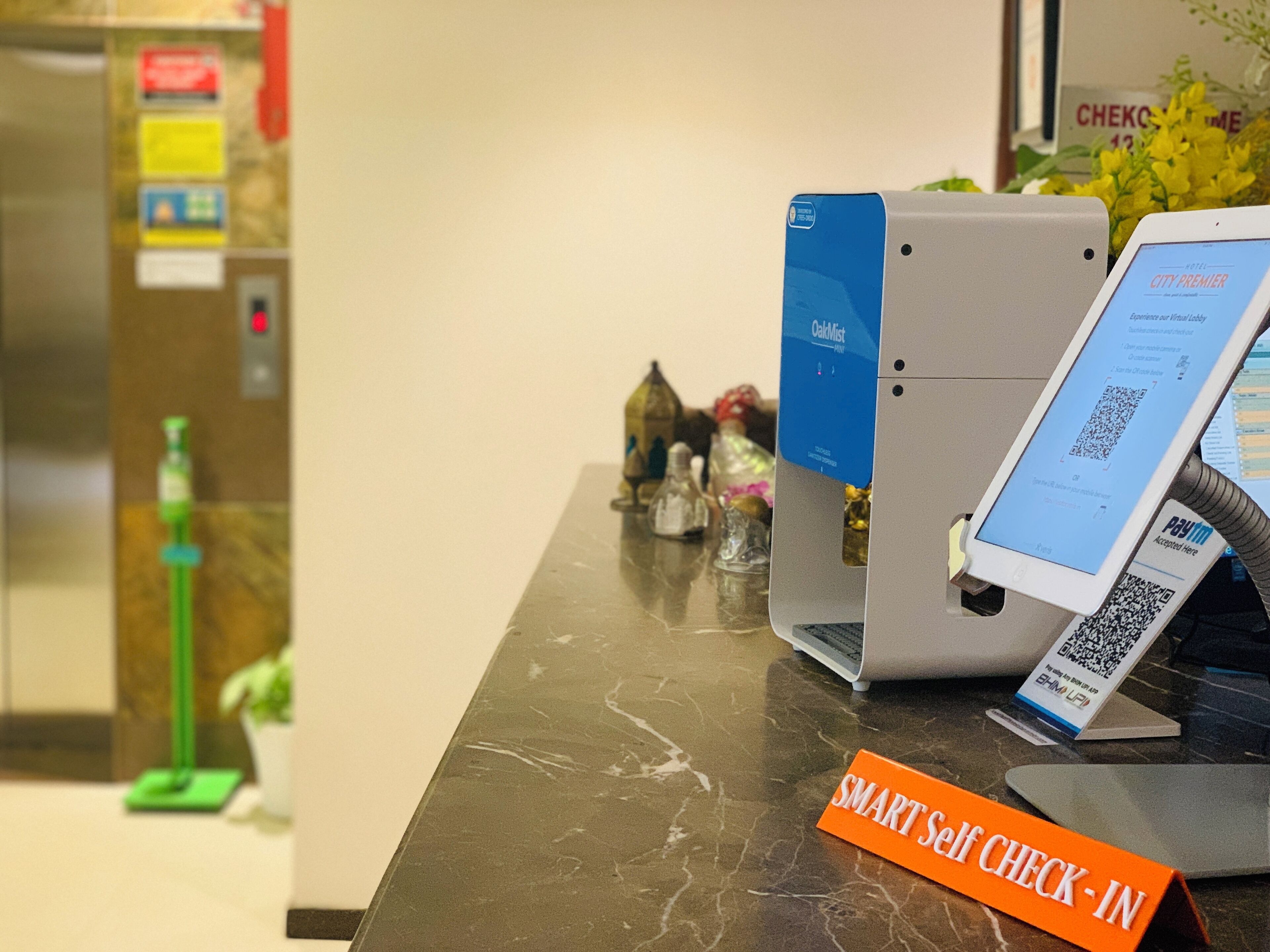 A self-check-in kiosk with a digital screen displaying a QR code and a sign indicating a smart self-check-in area.