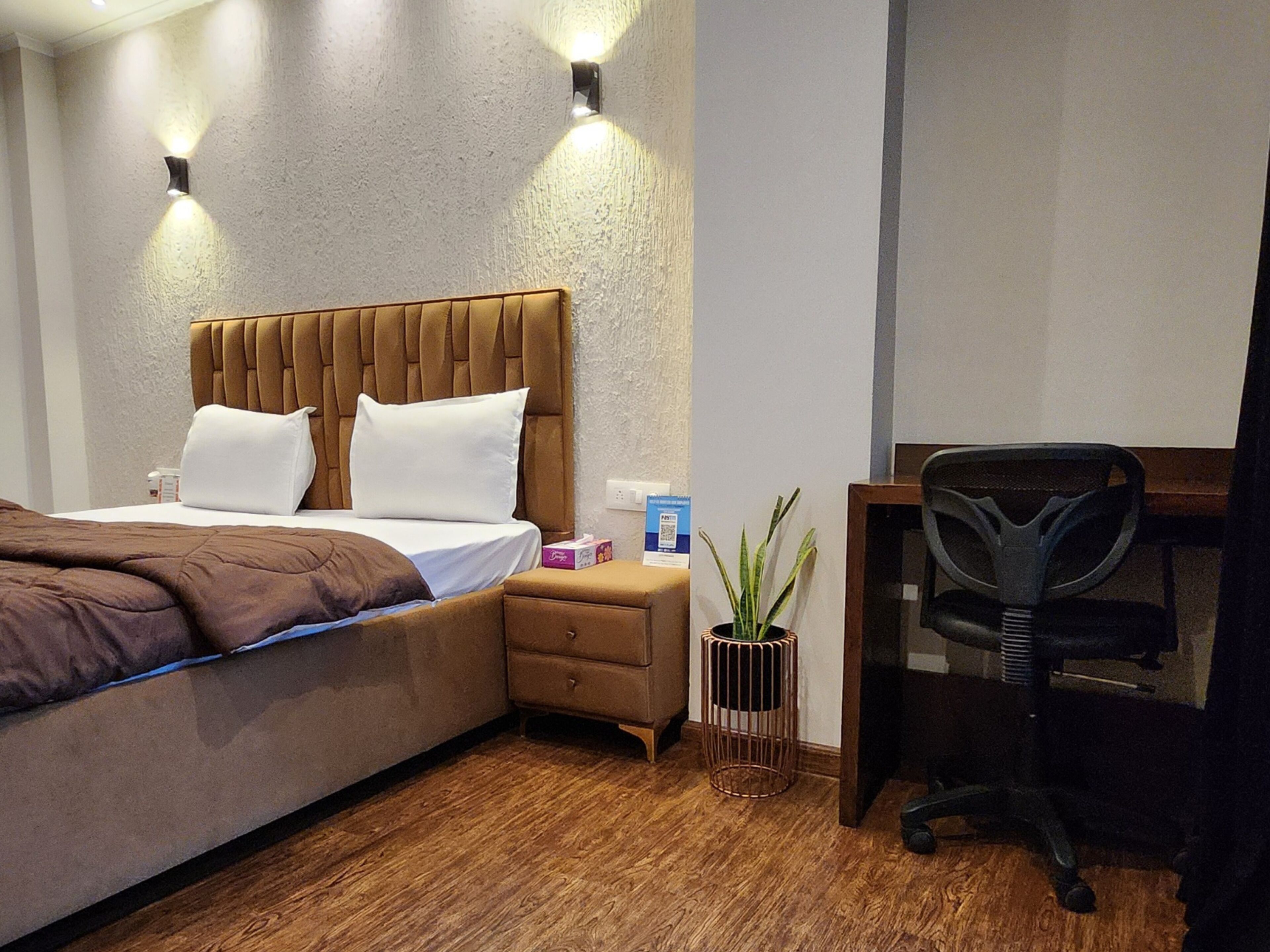 Une chambre d’hôtel avec un lit, un bureau et une chaise.