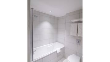 Un baño moderno con ducha acristalada, bañera blanca y un inodoro.