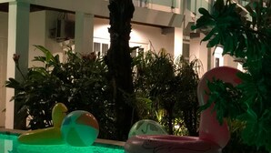 Une piscine intérieure avec des jeux gonflables, entourée de plantes d’intérieur et agrémentée d’un escalier.