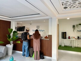 Un área de recepción con un diseño moderno, que incluye un mostrador de recepción, un televisor de pantalla plana y un logotipo en la pared.