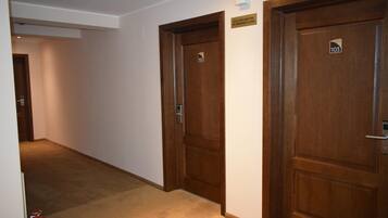 A hallway with three wooden doors, each marked with a number.