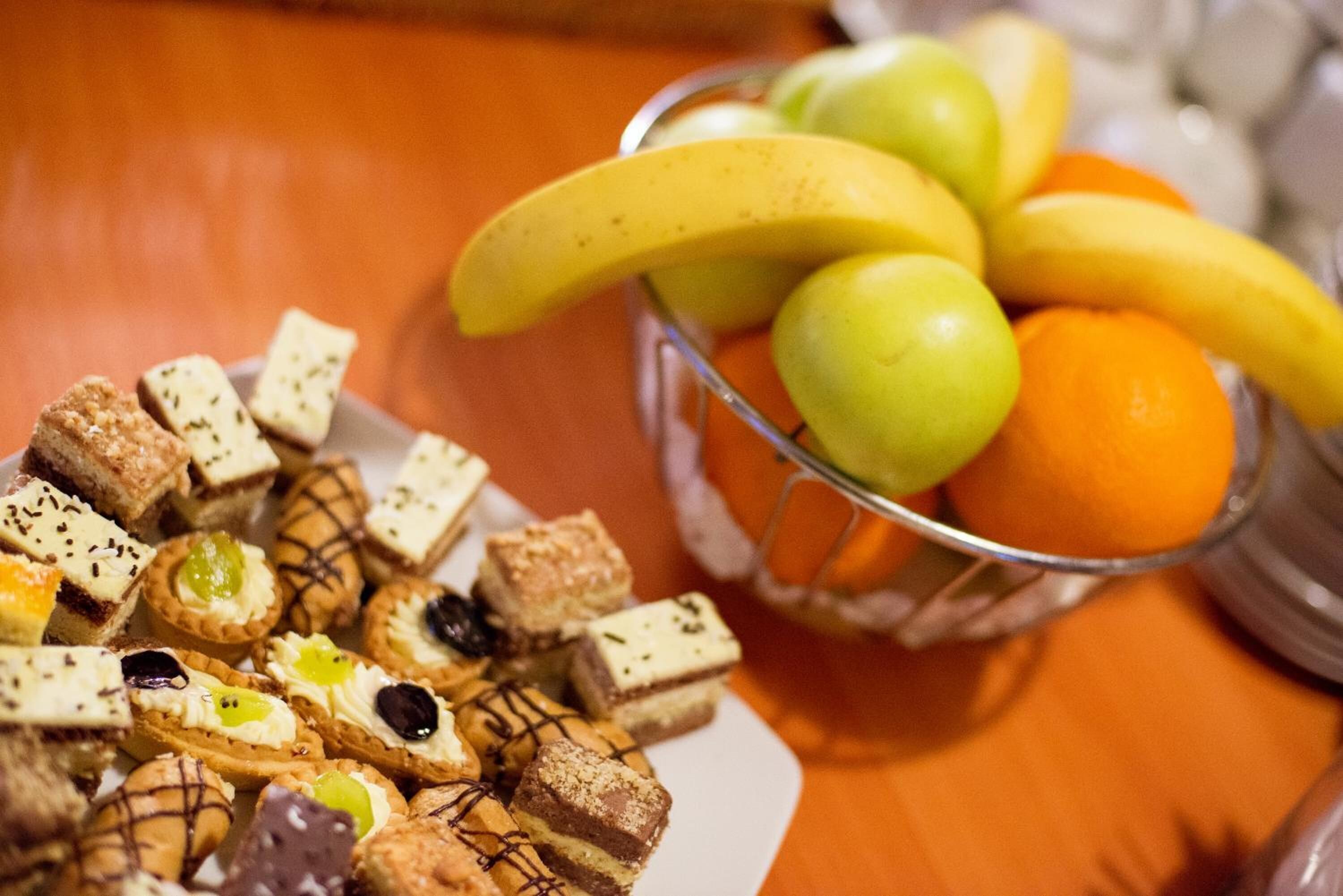 A plate of assorted pastries and a bowl of fruit.