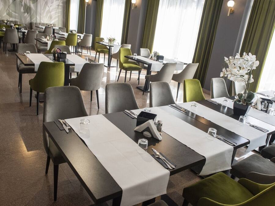 A restaurant with multiple tables, chairs, and a modern interior design.