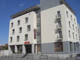 Un hôtel à plusieurs étages, doté d’une façade sobre, de nombreux balcons et d’une enseigne « HÔTEL » bien visible.