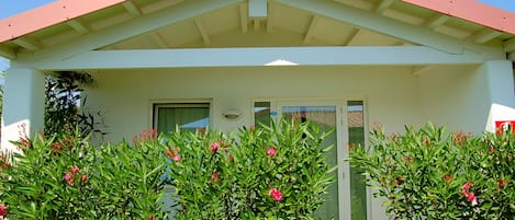 A building with a red roof and white walls, featuring a door and windows.