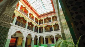 A multi-level interior with ornate arches and detailed tile work.