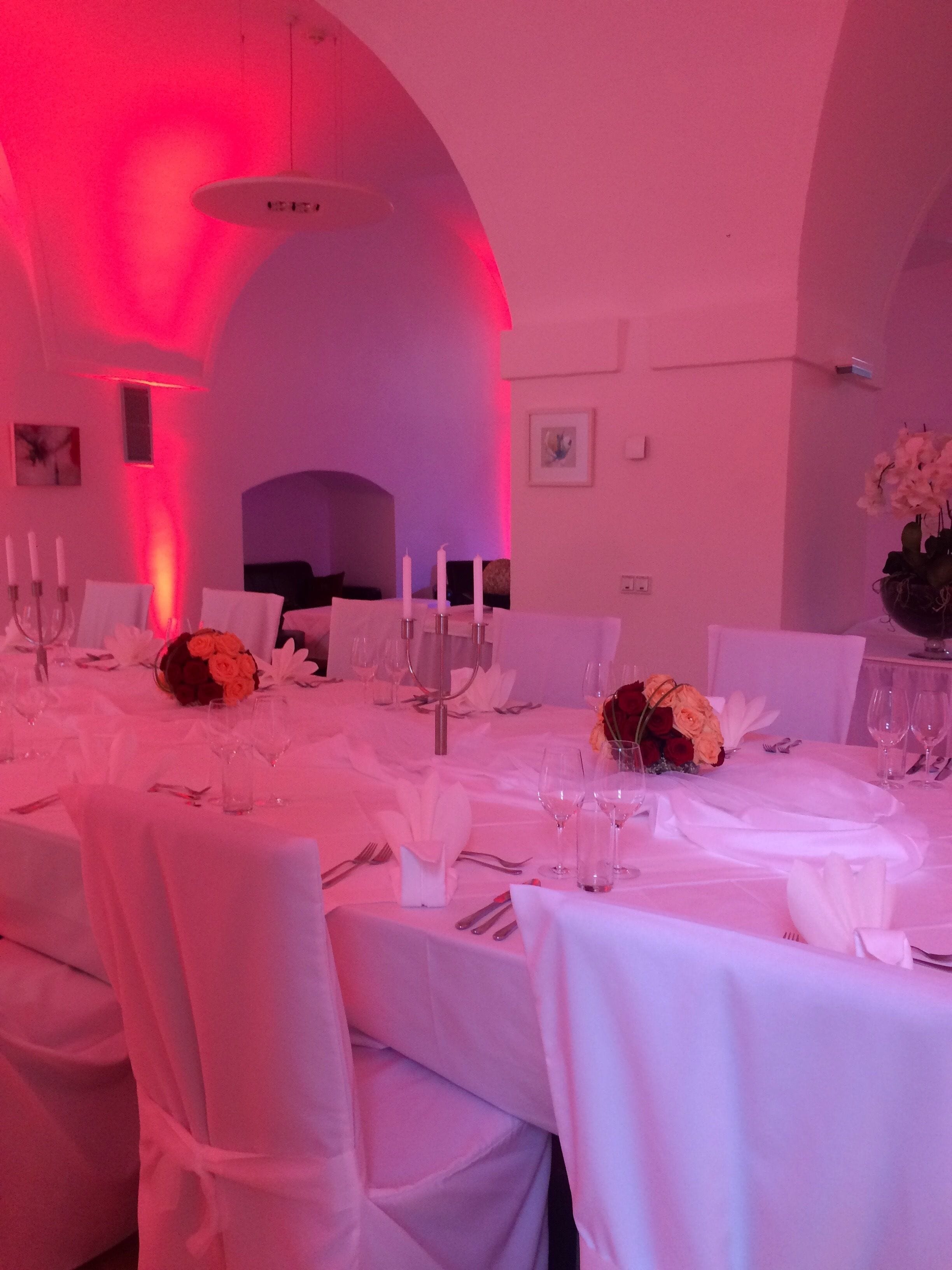 Un comedor formal con manteles blancos, candelabros y centros de mesa florales.