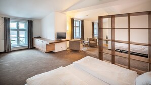 Une chambre d’hôtel moderne dotée d’un grand lit, d’un bureau avec une télévision, d’une chaise et offrant une vue sur l’extérieur.