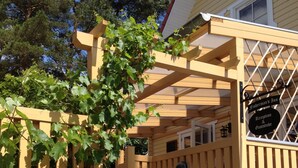 A wooden structure with a sign reading "Fisherman's Inn Reception & Gaststube" and a staircase leading to a vehicle. - Haus Stoertebeker Appartements - Hotel Garni (Lubmin)
