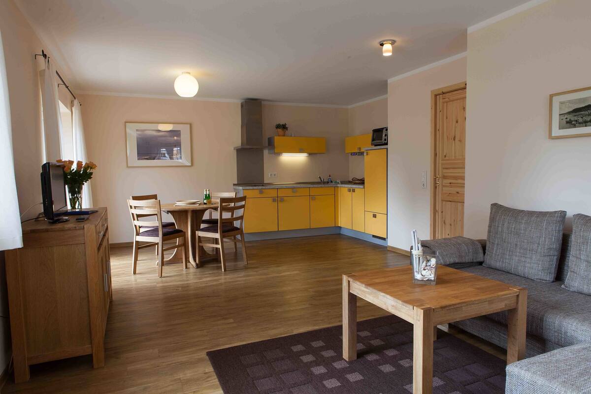 A compact living space with a dining area, kitchenette, and seating area.