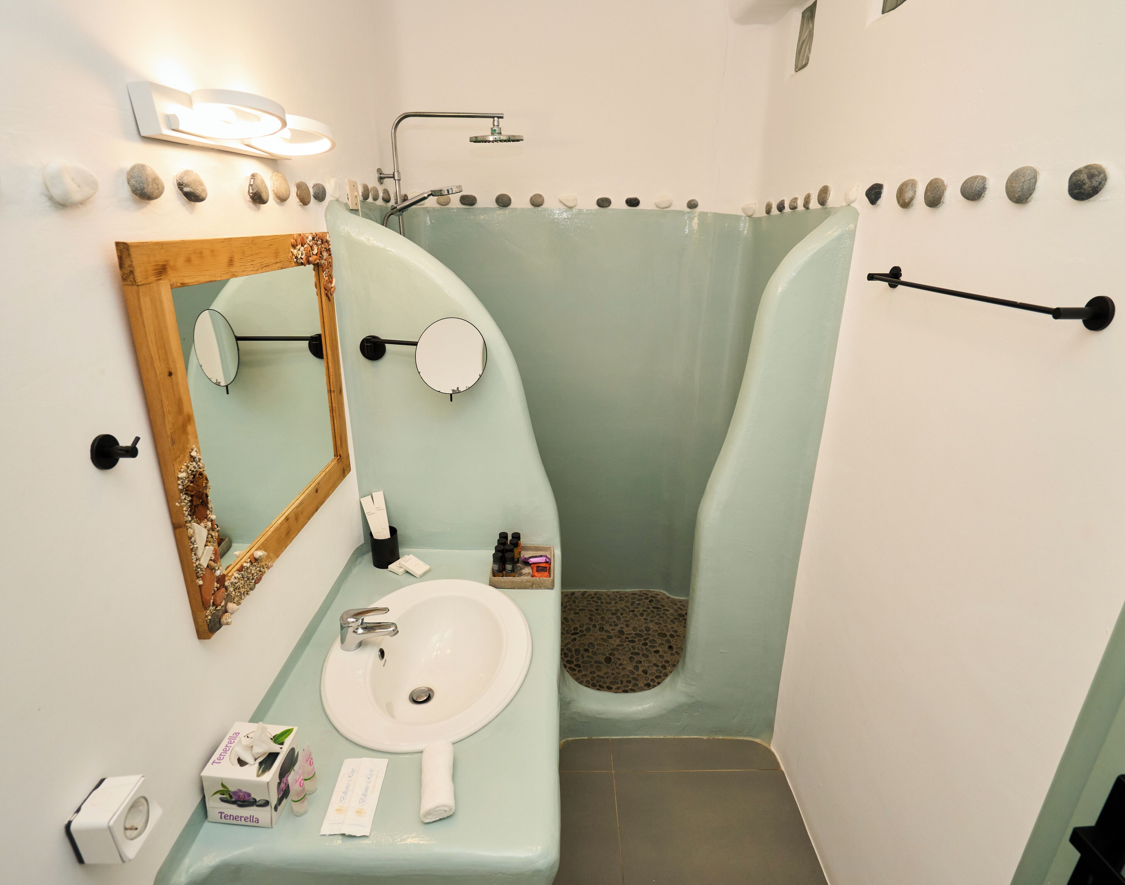A bathroom with a sink, mirror, and shower.