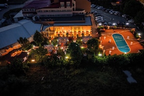 Un hotel con terraza, piscina y aparcamiento.