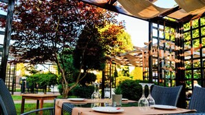 An outdoor dining area with tables, chairs, and a pergola structure. - Hotel Craiovita (Craiova)
