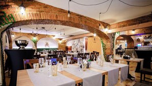 A restaurant with brick arches, tables set with glasses and cutlery, and a bar area. - Hotel Craiovita (Craiova)