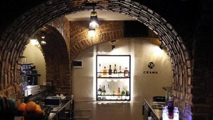 An interior with a brick archway, a bar area with shelves of bottles, and a sign reading 'CRAMA'. - Hotel Craiovita (Craiova)