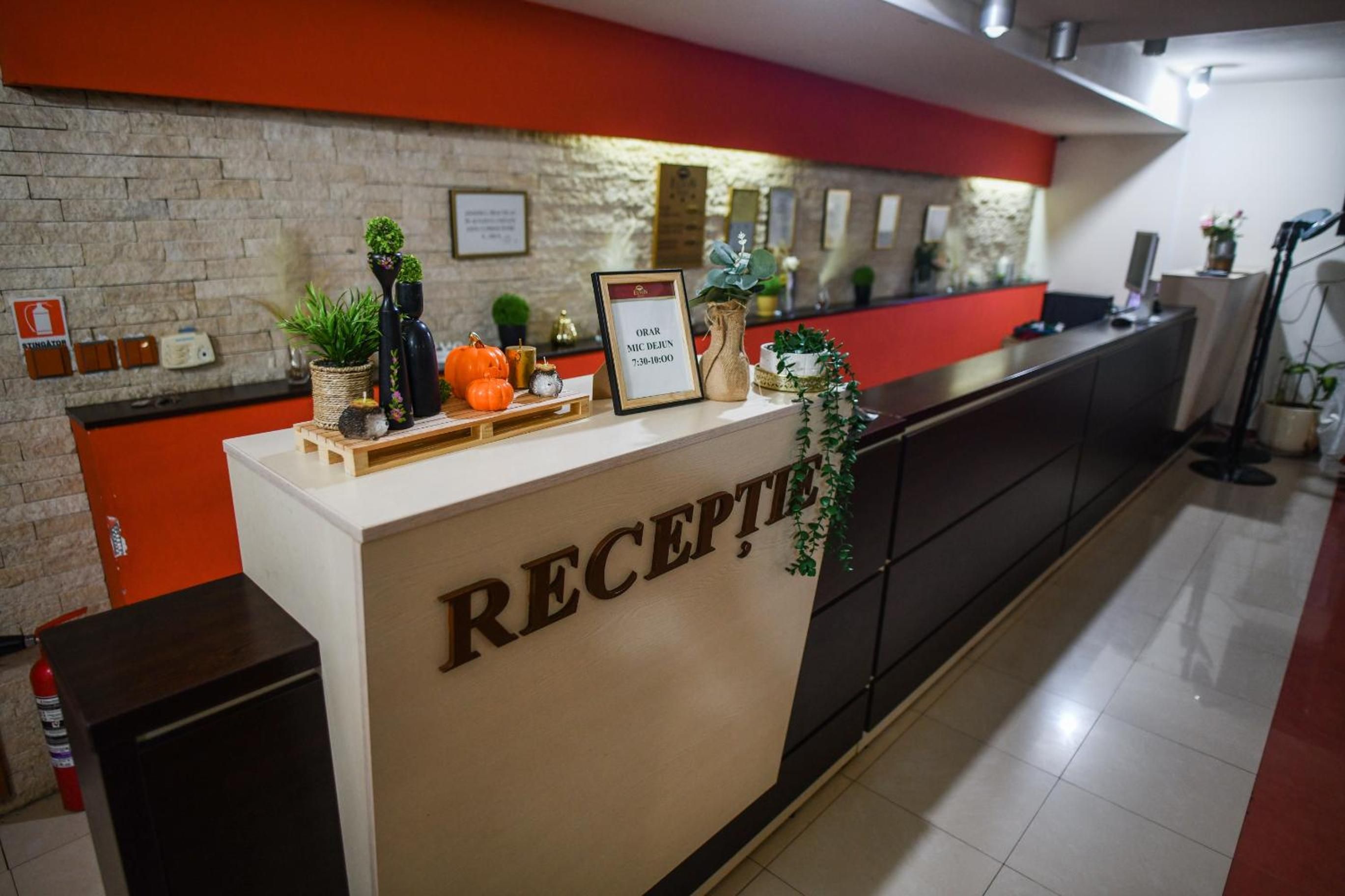 Una recepción con un cartel que dice 'RECEPCIE' y un aviso enmarcado arriba.