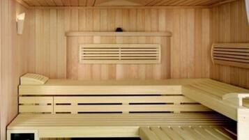 Een sauna met houten banken en een geblokt plafond.