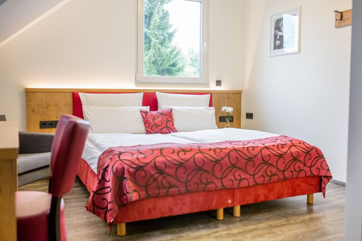 Un dormitorio con una cama, una ventana y una silla.