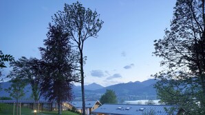 A modern house with a paved driveway, surrounded by trees and a mountain view. - Das Tegernsee (Tegernsee)