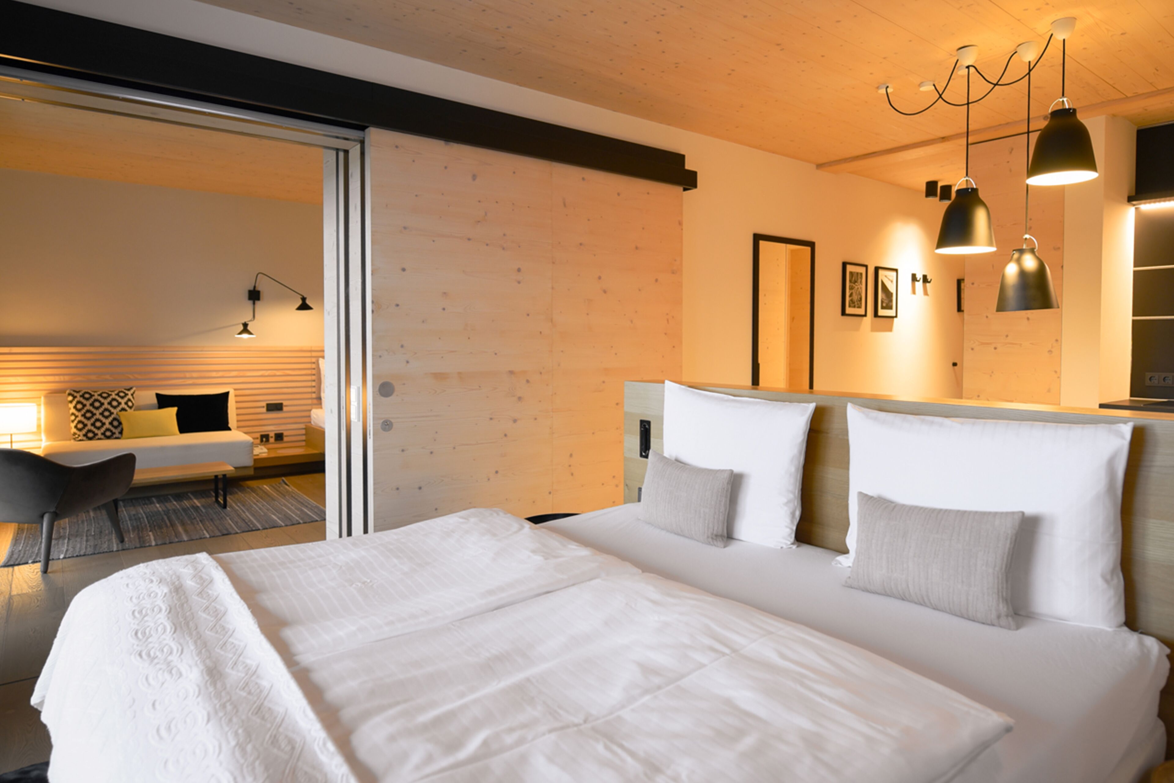 Una habitación de hotel moderna con una cama grande, un escritorio y una zona de estar.