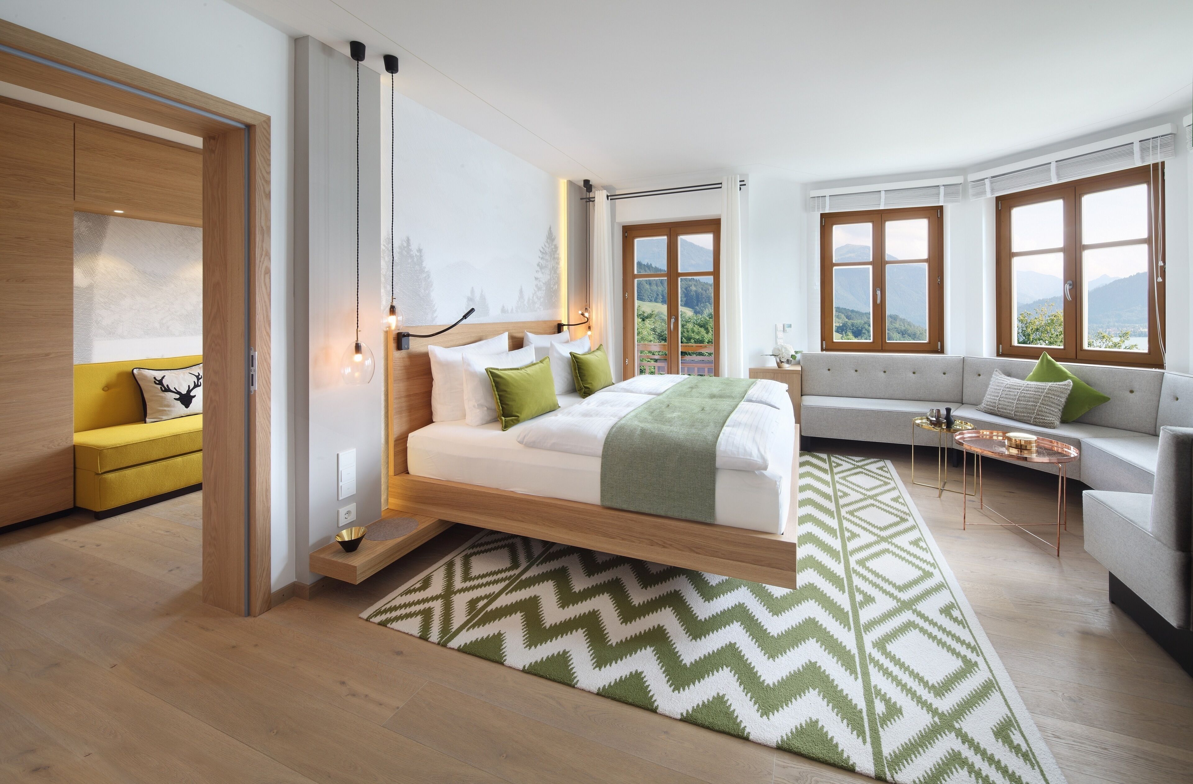 Una camera da letto moderna con un letto, un divano e vista sull'esterno.