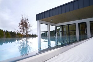 Una piscina techada, sillones reclinables de piscina