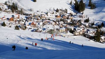 A snow-covered village with buildings and a ski slope.