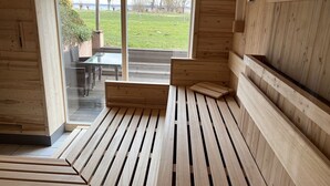Un intérieur en bois avec une porte en verre donnant sur un espace extérieur.