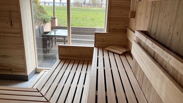 A wooden interior with a glass door leading to an outdoor area. - Flair Seehotel Zielow (Südmüritz)