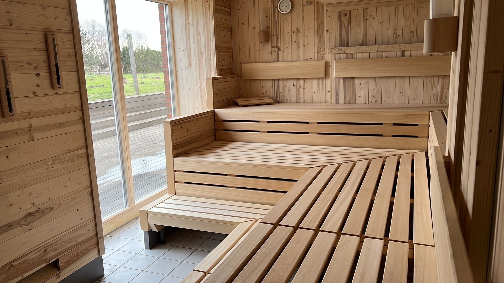 Una sauna de madera con bancos y un reloj en la pared.
