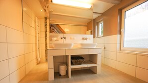 Uma casa de banho moderna com duas lavatórios, uma janela e um armário embutido.