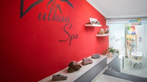 A red wall with the name 'Vulkan Spa' and a mountain graphic. There are shelves with rocks and a small table with chairs. - AKZENT Hotel Haus Sonnenberg (Schotten)