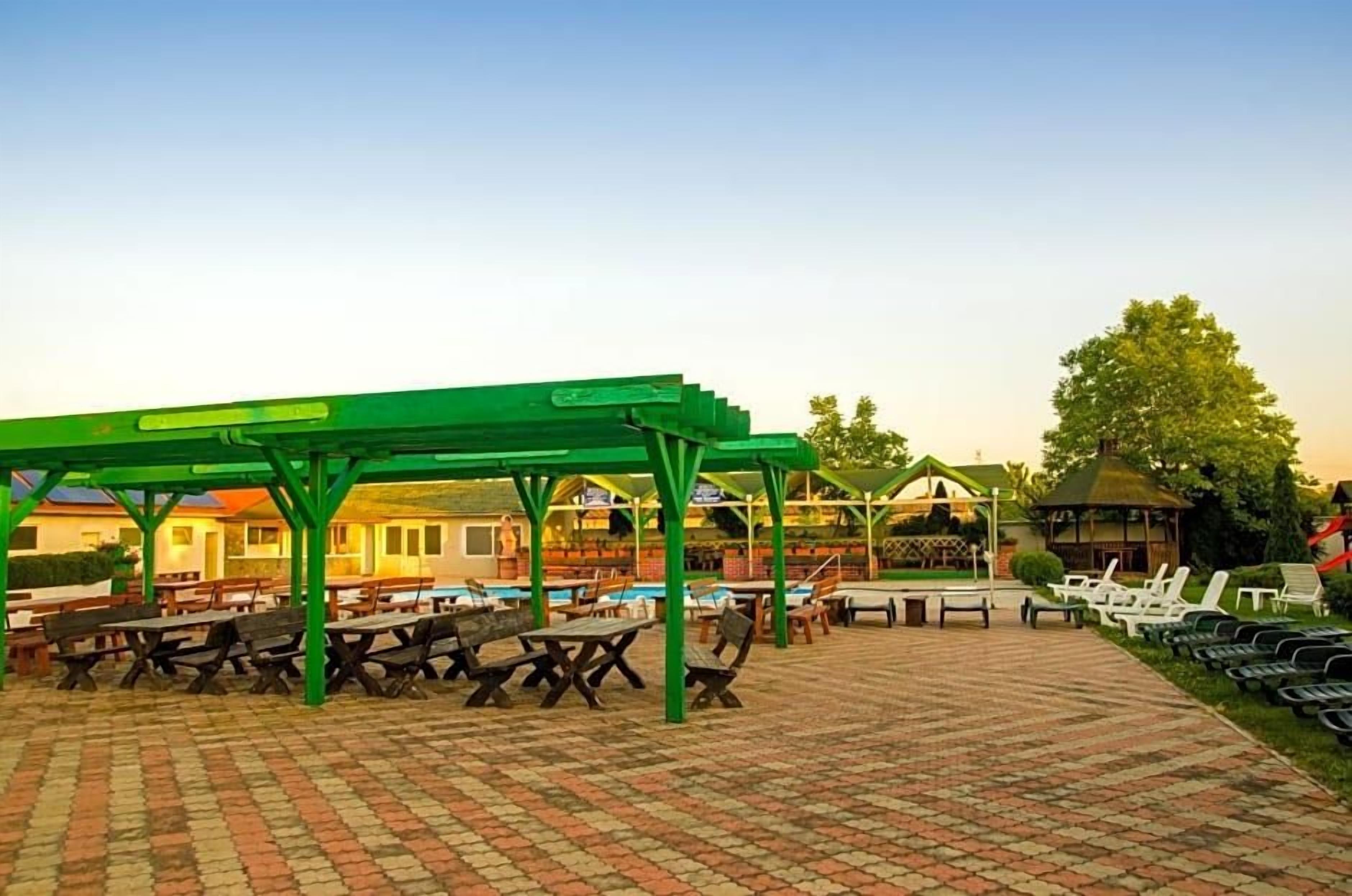Un patio al aire libre con mesas de picnic y un área de estar cubierta.