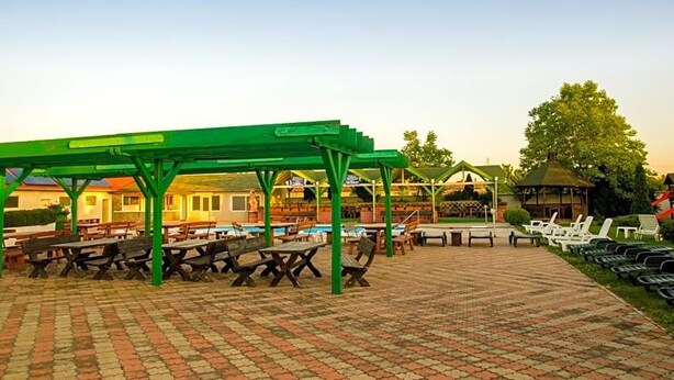 Eine Außenpatio-Terrasse mit Picknicktischen und einem überdachten Sitzbereich.